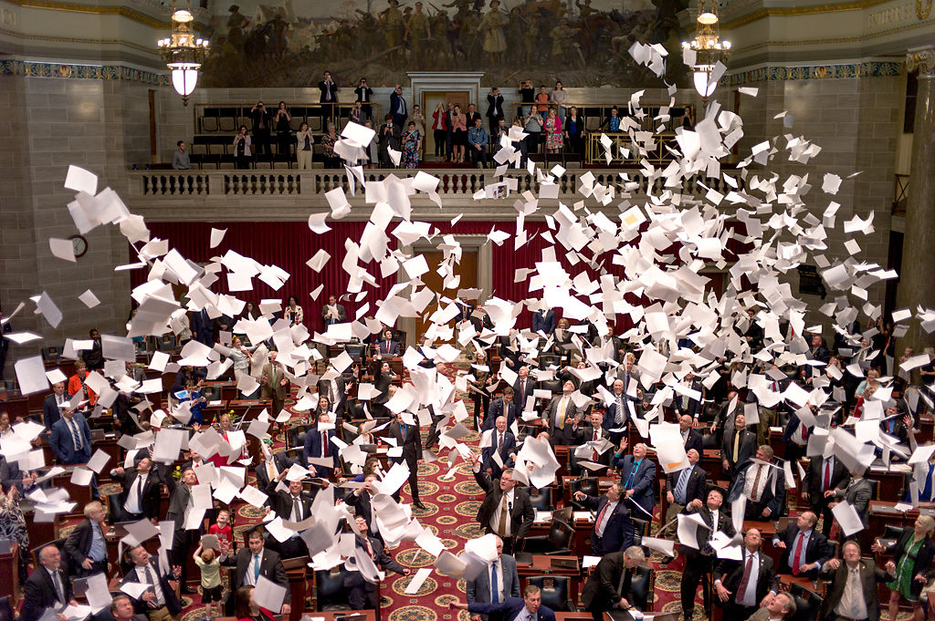 Representatives throw paper into the air at the end of 2019 legislative session